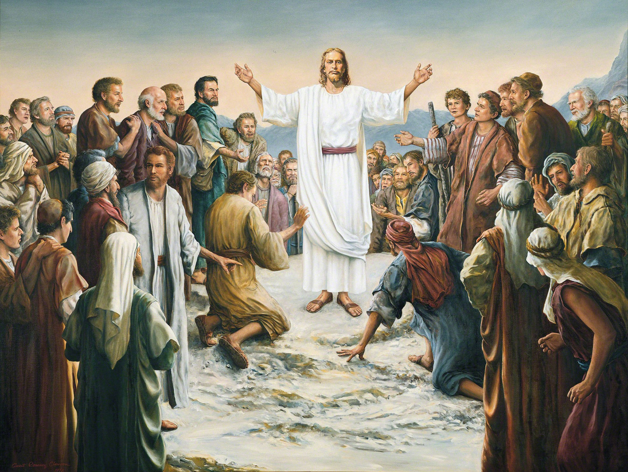 Jesus stands on a rock in the middle of a large group of people. He wears a white robe, red sash and white shoulder sash. The people are in various attitudes of speaking to one another and worshipping him